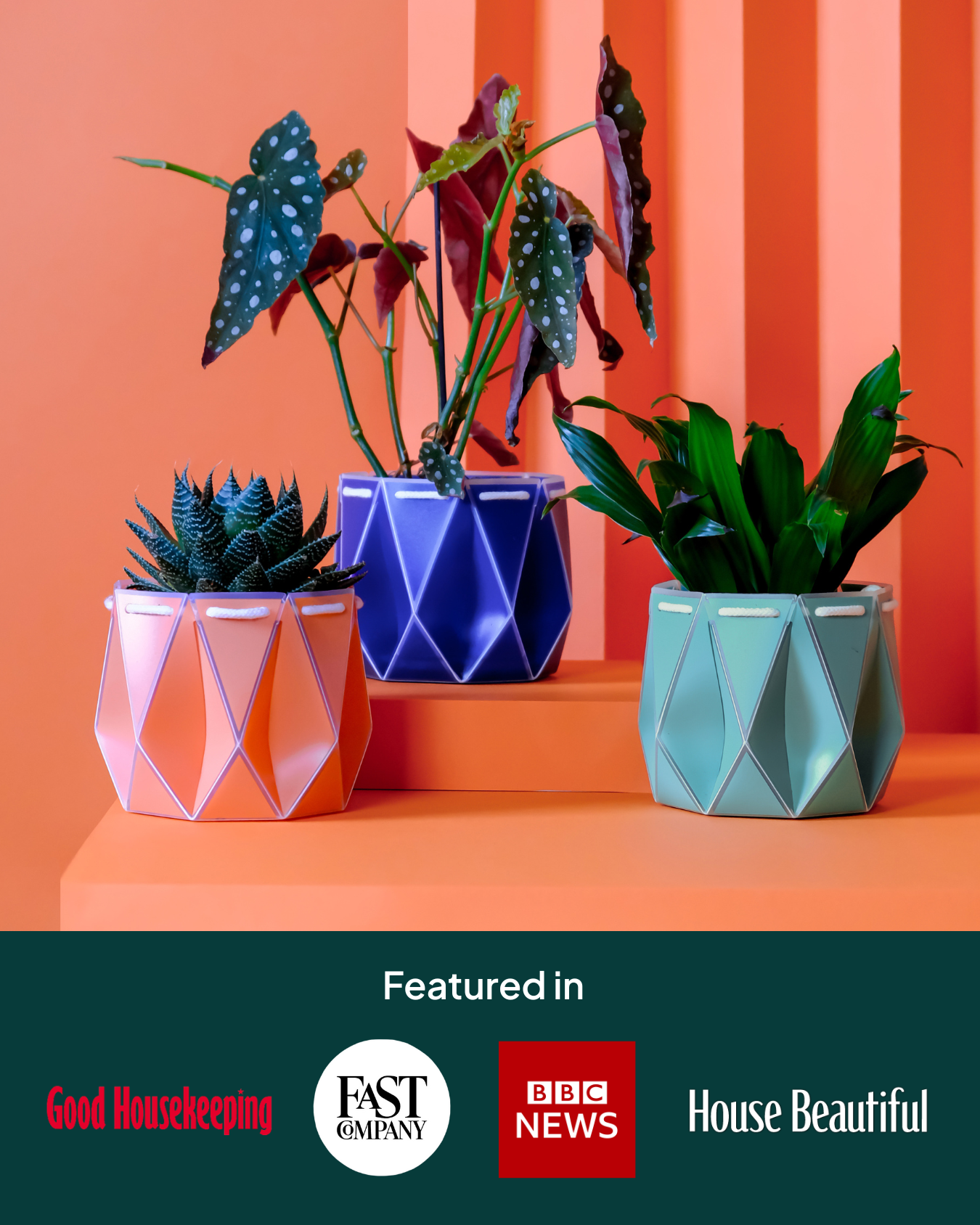 Three assembled POTR self-watering pots in coral, navy, and aqua blue, each holding a houseplant. They’re staged against a vibrant orange backdrop with logos of featured press outlets: Good Housekeeping, Fast Company, BBC News, and House Beautiful.