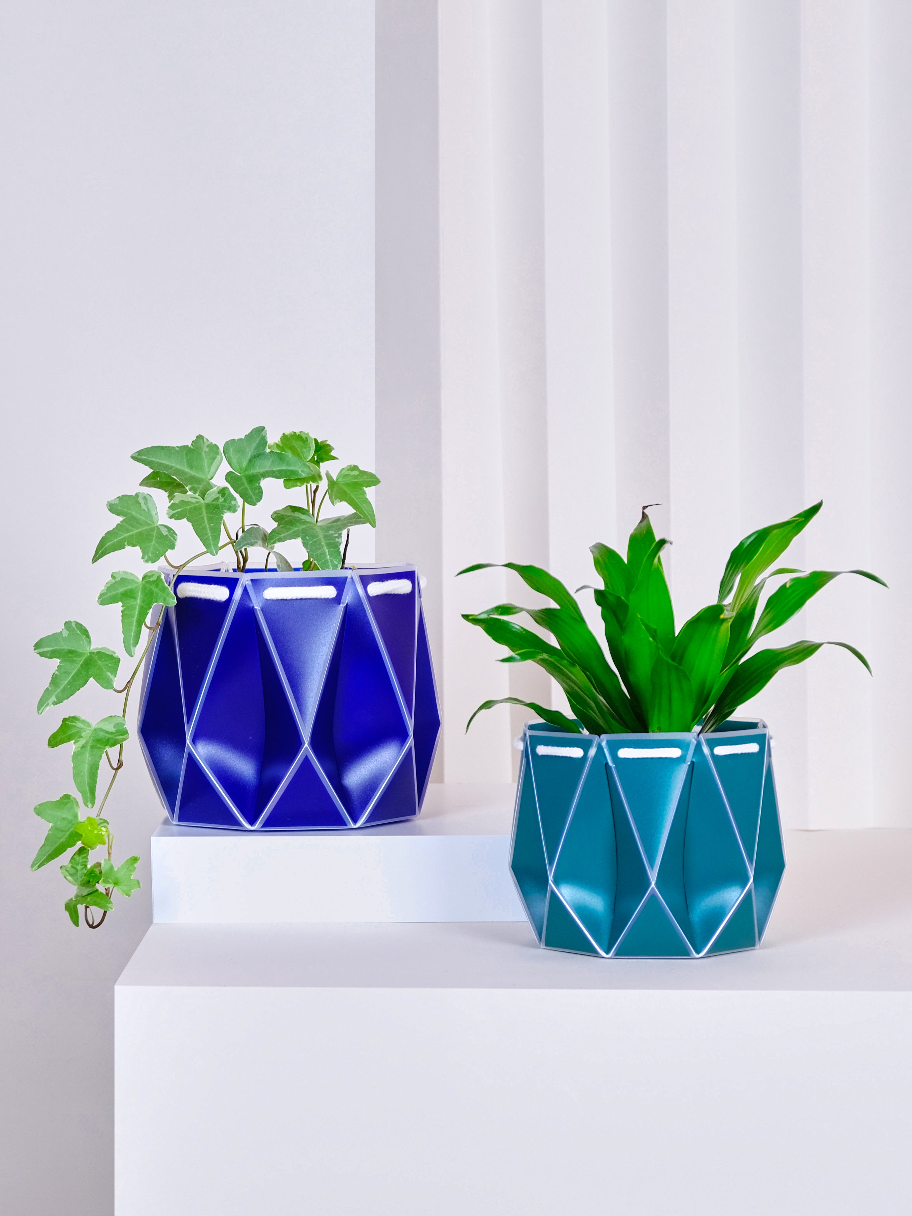 Navy blue and teal origami plant pots made from recycled plastic. Eco sustainable design used to self-water your plants.