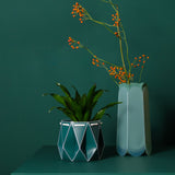 Origami flat packed self-watering plant and folding letterbox vase. Pine green colour.