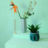 Origami plant pot and vase designed to self-water. Minimal design in mint green and teal.
